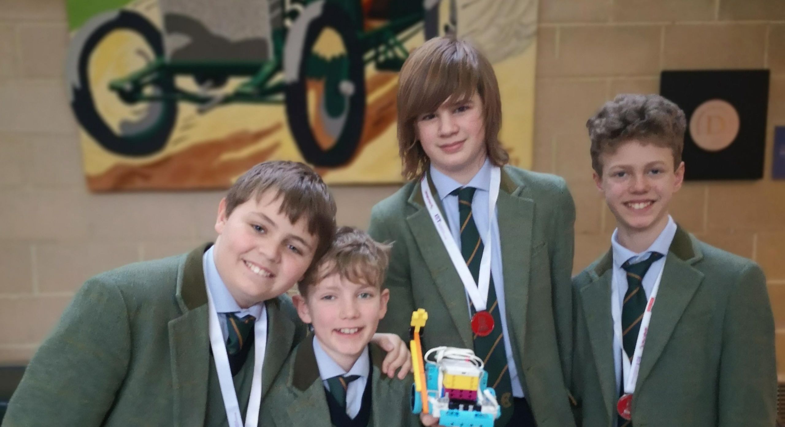 Four male students pose for a picture after a lego league challenge